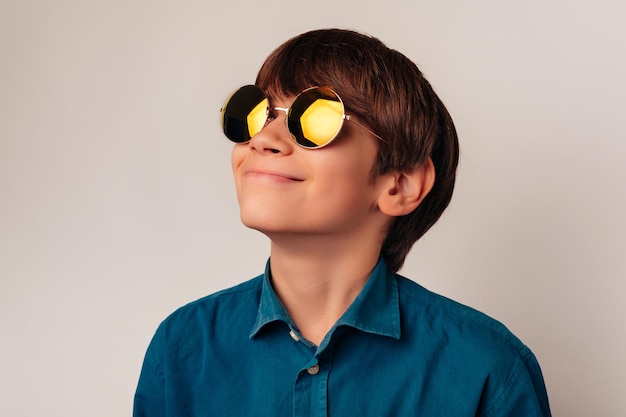 Un chico guapo con camisa azul y gafas de sol geniales está sonriendo