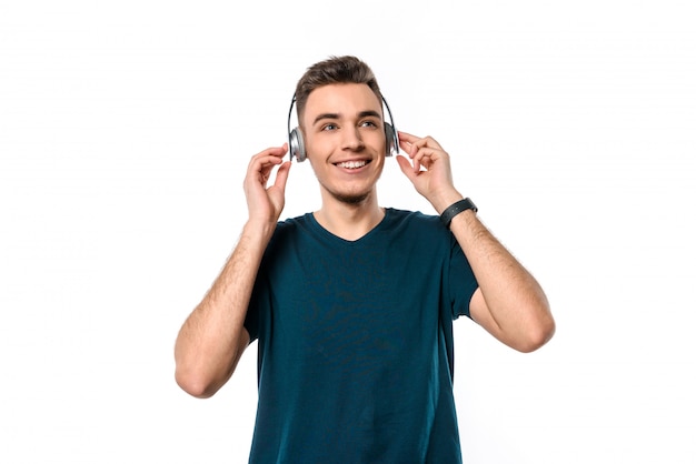 Foto chico guapo joven con auriculares escuchando música