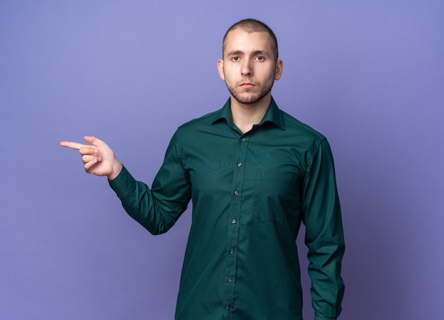 Chico guapo joven confiado con puntos de camisa verde al lado