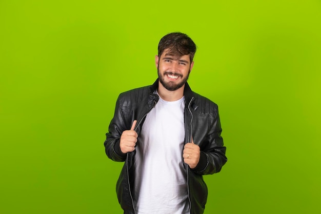 Chico guapo joven sonriendo a la cámara aislada sobre fondo verde Chico joven con una sonrisa segura mirando a la cámara