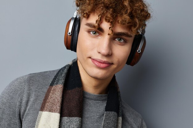 Chico guapo plaid bufanda auriculares inalámbricos tecnología aislado fondo