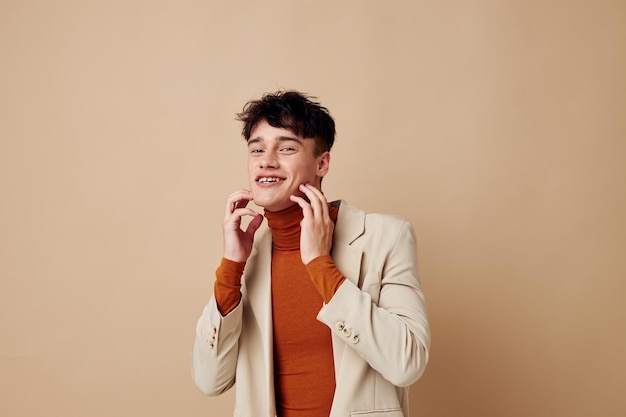 Chico guapo posando con un teléfono en sus manos en una chaqueta estilo elegante fondo aislado inalterado