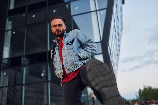 Un chico guapo con ropa informal está al aire libre durante el día soleado