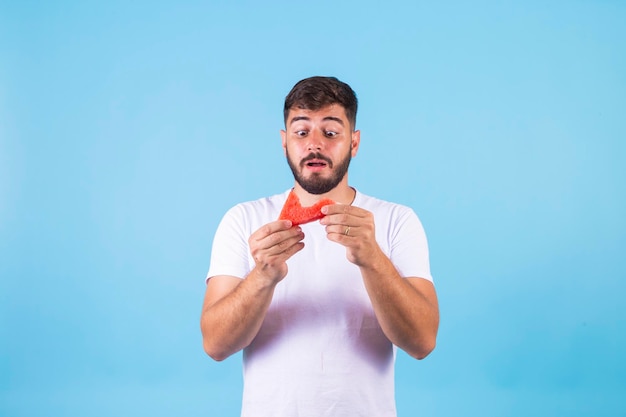 Chico guapo sano joven comiendo sandía