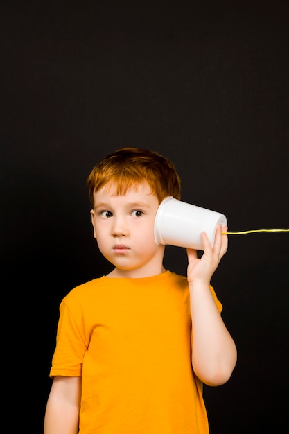 chico habla por un simple teléfono casero