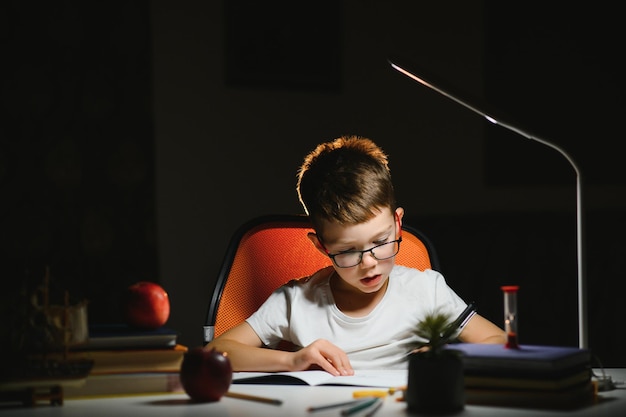 Foto chico haciendo los deberes en casa por la noche