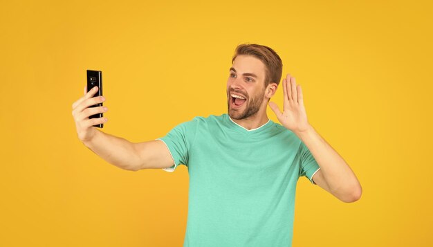 chico haciendo videoblog en smartphone blogueando en teléfono influencer o asesor hombre feliz haciendo selfie blogger masculino vlogger con teléfono celular mostrar gesto de hola