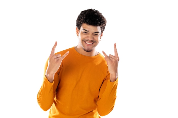 Chico joven afro mostrando gesto de rock con los dedos aislado sobre un fondo blanco.