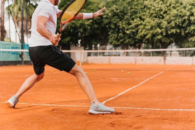 Foto chico joven atlético jugando al tenis