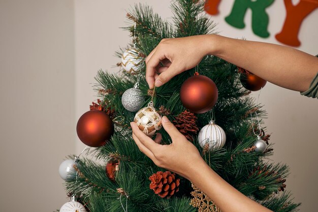 Chico joven atractivo en el árbol de Navidad