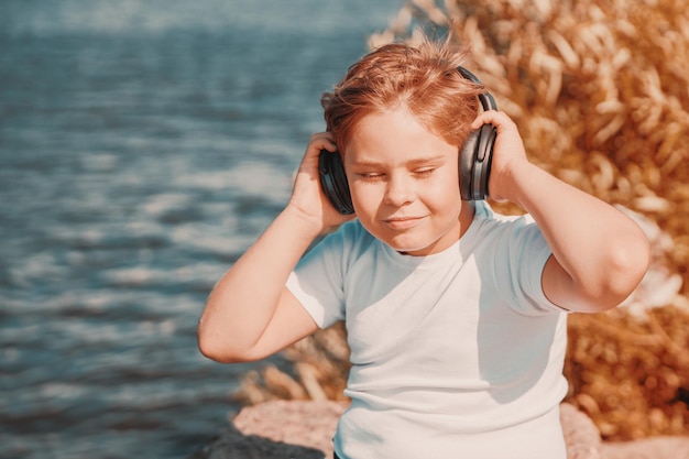 Chico joven con auriculares escuchando música al aire libre