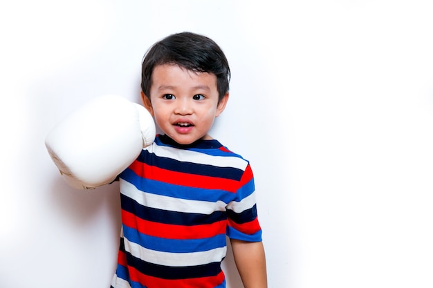 Chico joven boxeador asiático con guantes de boxeo blancos sonriendo sobre fondo blanco