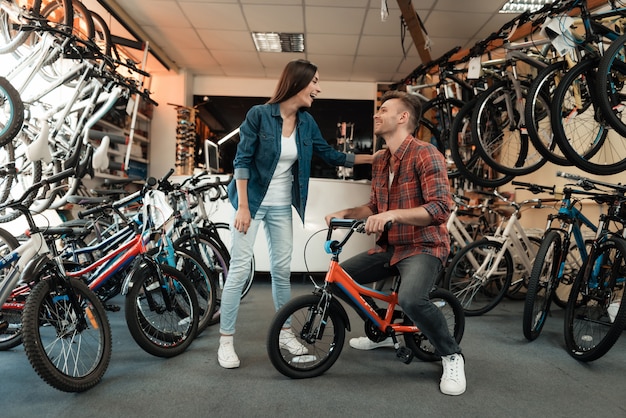 Un chico joven y una chica están eligiendo una bicicleta para niños.