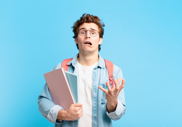 Chico joven estudiante que parece desesperado y frustrado, estresado, infeliz y molesto, gritando y gritando