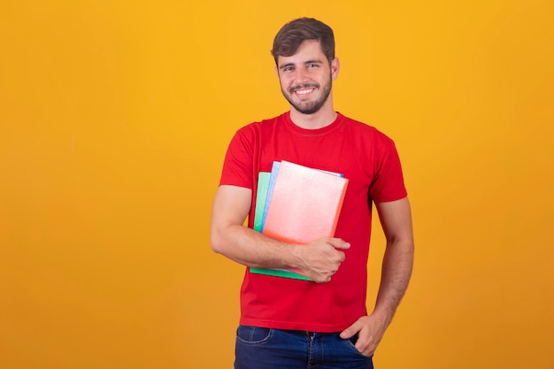 Chico joven estudiante sobre fondo amarillo chico estudiante feliz