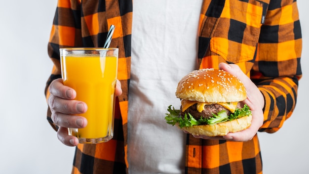 Un chico joven con una hamburguesa fresca.