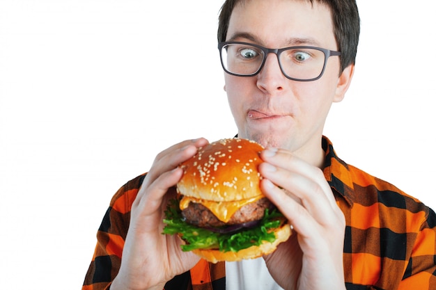 Un chico joven con una hamburguesa fresca.