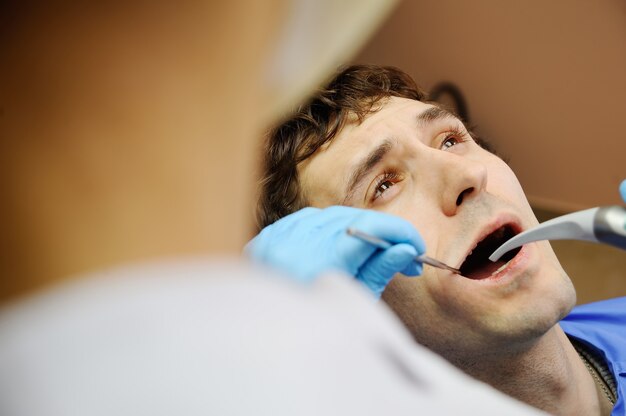 Chico joven en la oficina dental. miedo a los dentistas