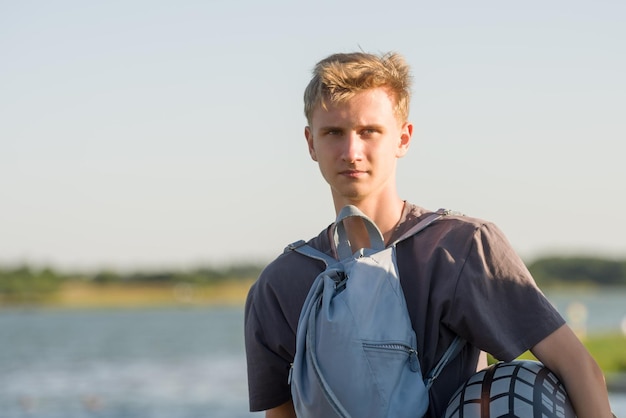 Un chico joven en la orilla del lago.