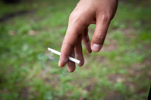 Chico joven sosteniendo un cigarrillo