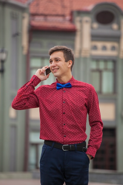 Chico joven con un teléfono en un edificio histórico