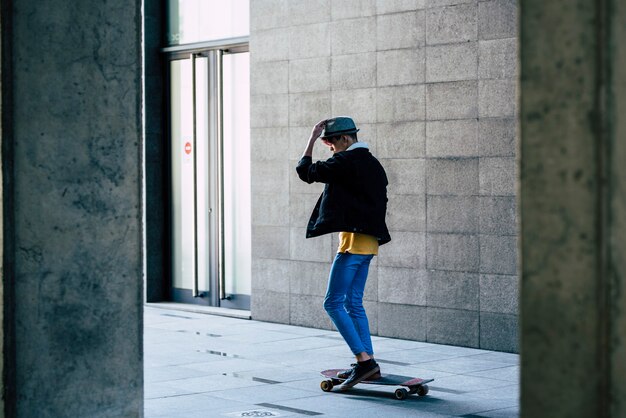 Chico joven usa patineta en la ciudad Concepto de gente joven y transporte moderno y moderno