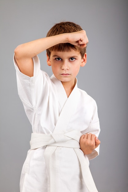 Chico de karate en kimono blanco luchando