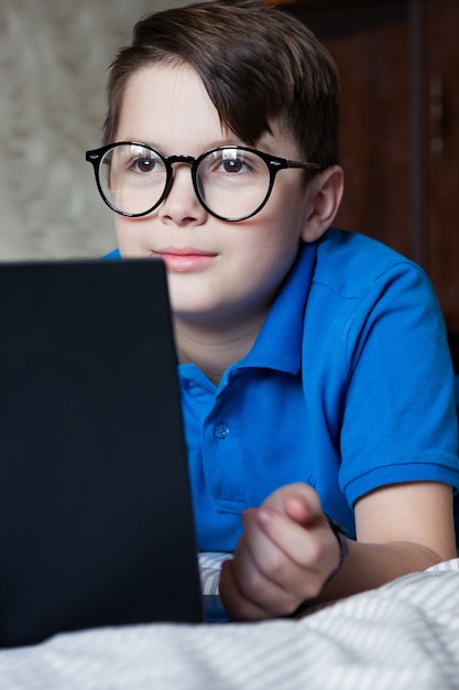 Chico con laptop aprendiendo en línea. Cuarentena. Lección en línea en el hogar, distancia social, concepto de educación en línea, educación en el hogar.