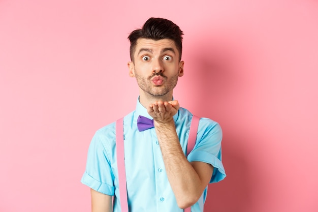 Chico lindo enviando un beso al aire a la cámara y diciendo te amo en el día de San Valentín