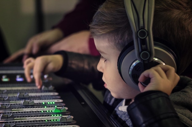 Un chico lindo mezclando música en un estudio de grabación.