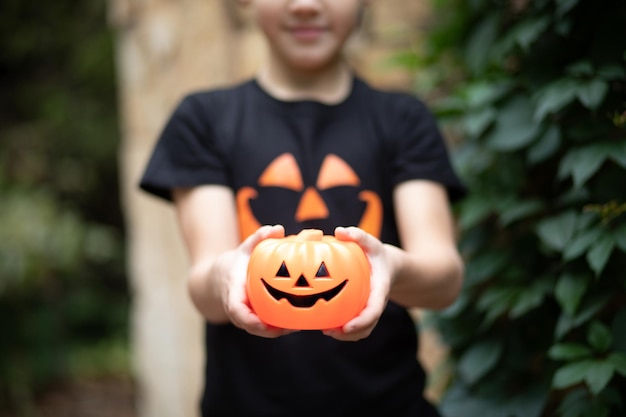 Chico lindo niño en camiseta de calabaza jackolantern sosteniendo linterna en vacaciones de Halloween