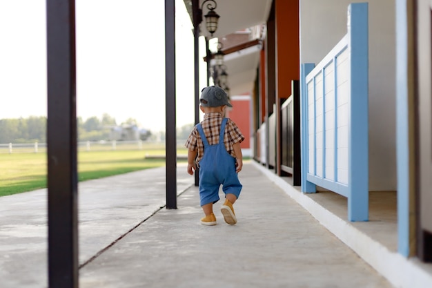 Chico lindo niño en jeans caminando por el camino