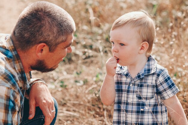 Chico lindo con papá juega al aire libre