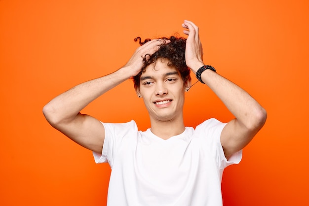 Chico lindo con el pelo rizado en un primer plano de camiseta blanca