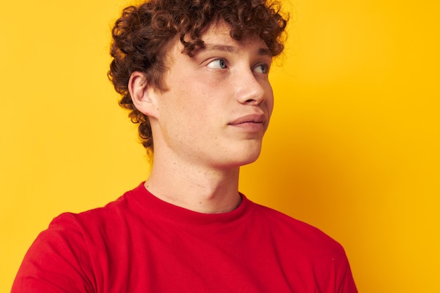 Chico lindo con el pelo rizado en un primer plano de camiseta roja