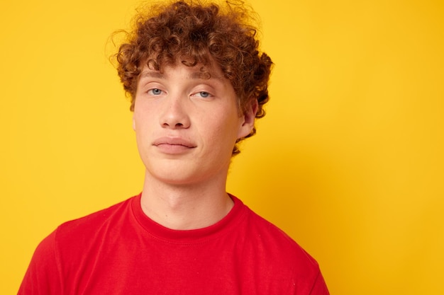 Chico lindo con el pelo rizado en un primer plano de camiseta roja