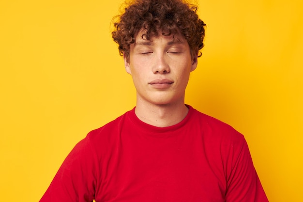 Chico lindo con el pelo rizado en un primer plano de camiseta roja