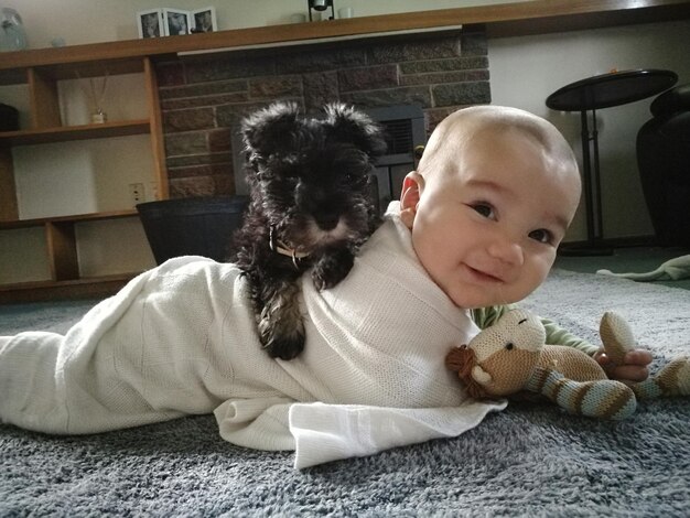 Foto un chico lindo con un perro en casa.