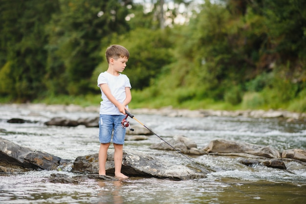 Chico lindo pescando en el río