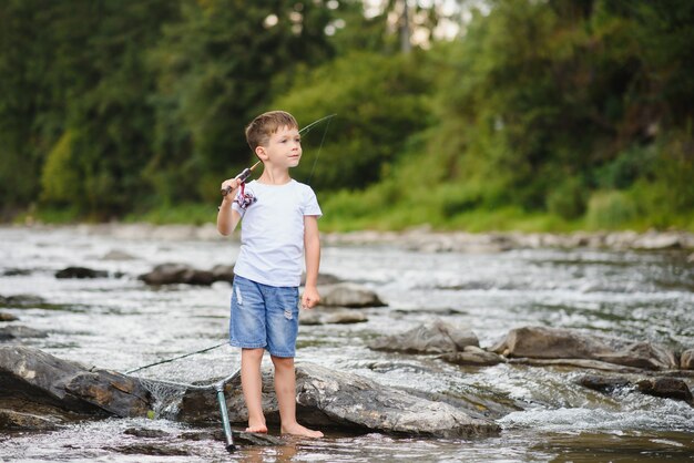 Chico lindo pescando en el río