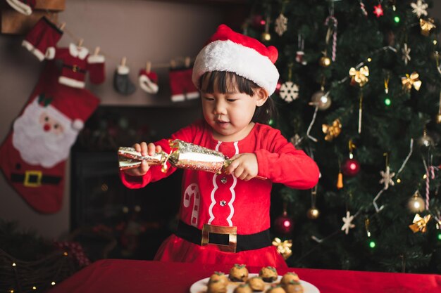 Foto un chico lindo con un regalo de navidad por la comida.