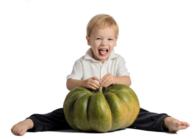 Chico lindo sentado con calabaza aislado