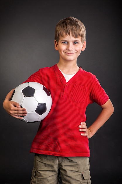 Chico lindo sostiene un balón de fútbol