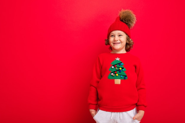 Chico lindo con un suéter de Navidad y un sombrero