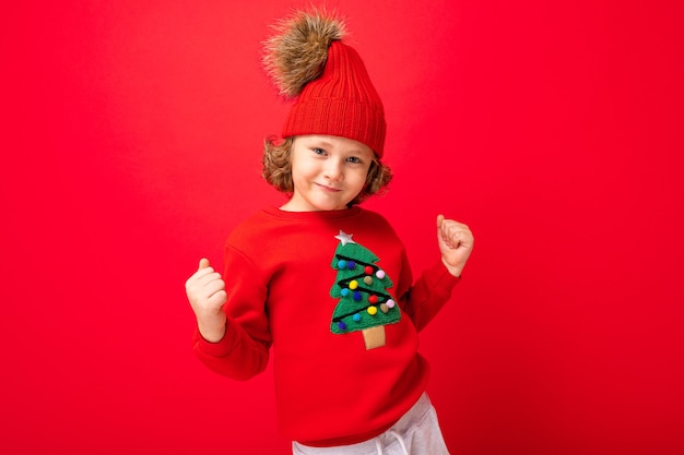 Chico lindo con un suéter de Navidad y un sombrero