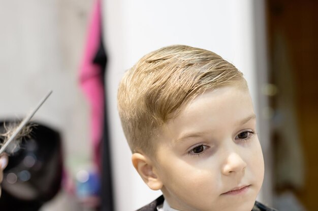 Foto el chico lindo tiene un nuevo peinado en el salón.