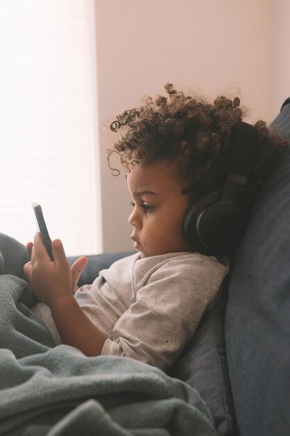 Un chico lindo usando el teléfono móvil en casa.