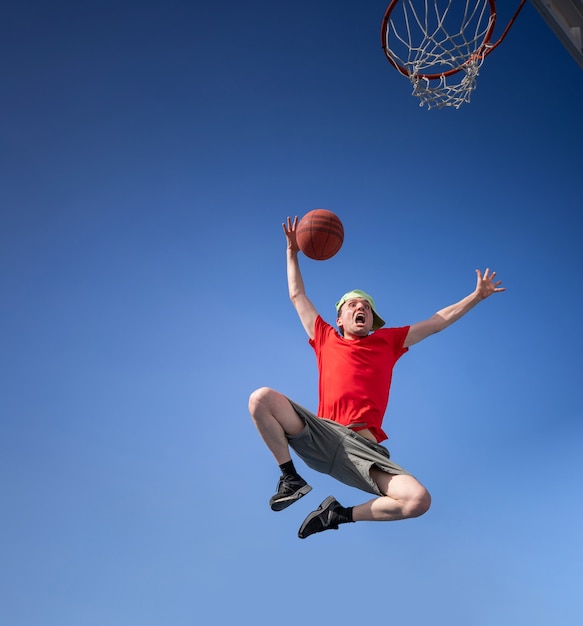 Chico loco divirtiéndose riendo y jugando baloncesto