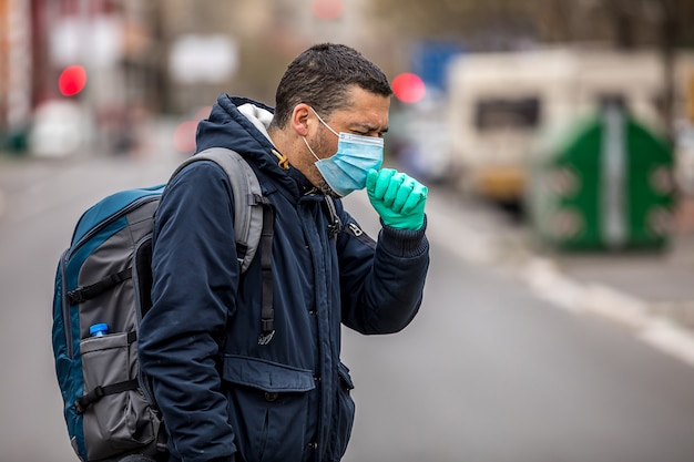 Chico con máscara protectora de virus al aire libre en la gente crowdy. Concepto de vida de salud y seguridad del coronavirus