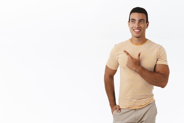 Chico masculino casual relajado de pie fondo blanco cerca de un claro espacio en blanco vacío